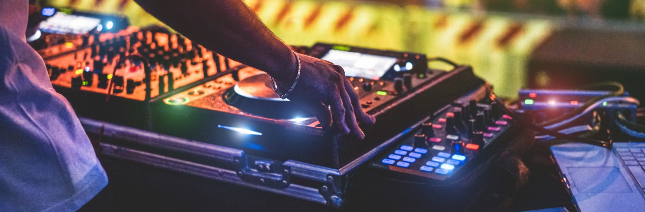 Dj mixing outdoor at new year party festival with crowd of people in background - Nightlife view of disco club outside - Soft focus on bracelet, hand - Fun ,youth,entertainment and fest concept